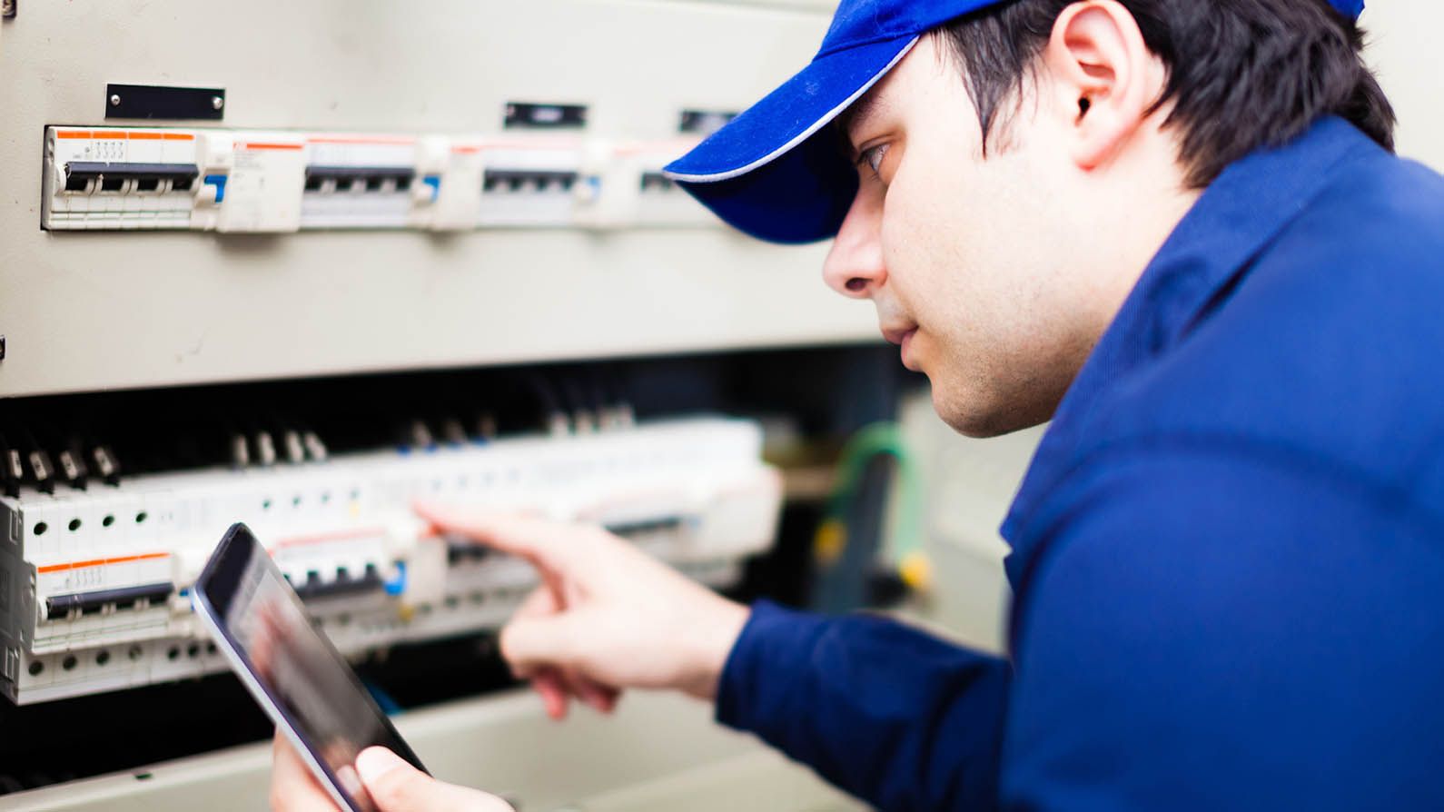 installer with smart phone on switch board