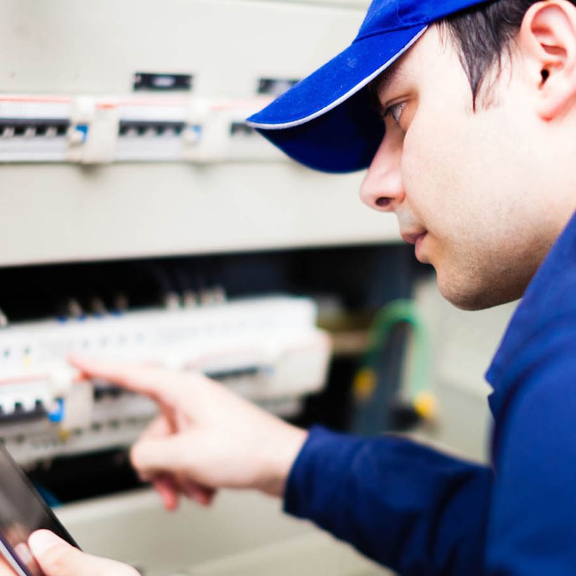 installer with smart phone on switch board